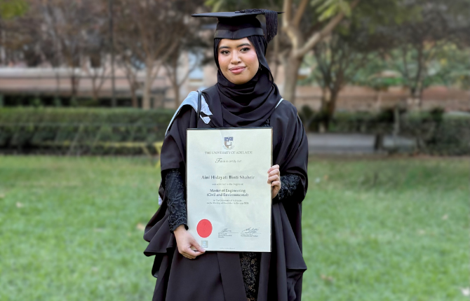 A smiling girl hold her parchment on graduation day